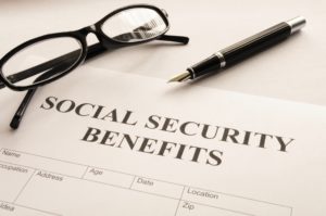 social security benefits document with glasses and a pen above it