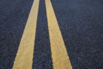 Hazardous Roadways & Personal Injury - Closeup asphalt road with marking lines for giving directions, traffic lines concept