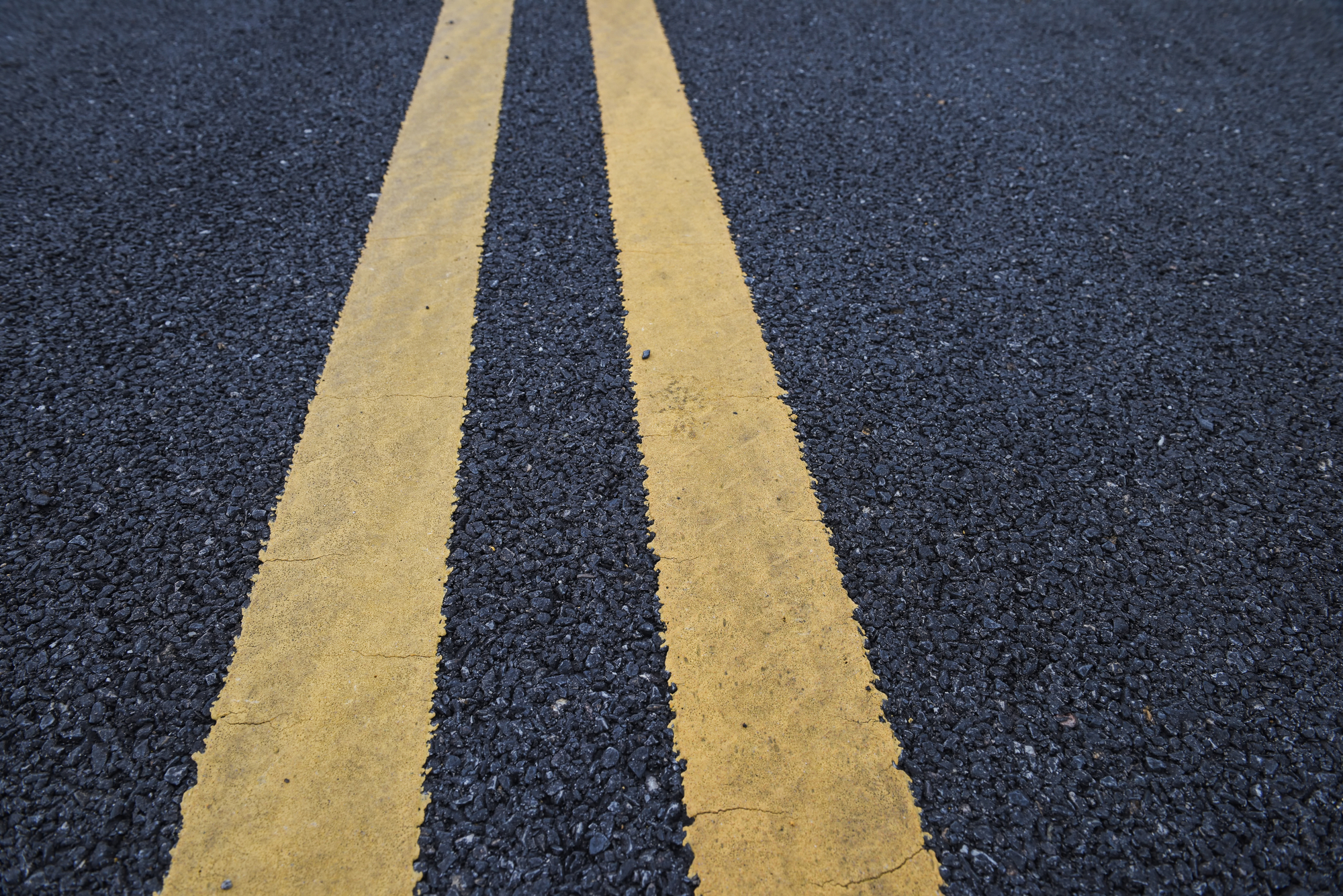 Hazardous Roadways & Personal Injury - Closeup asphalt road with marking lines for giving directions, traffic lines concept