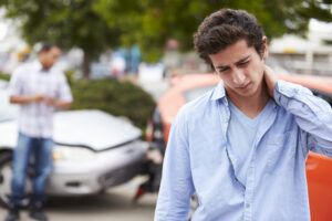 Personal Injury Lawyer Milwaukee, WI with a man holding neck in front of a rear-end car accident